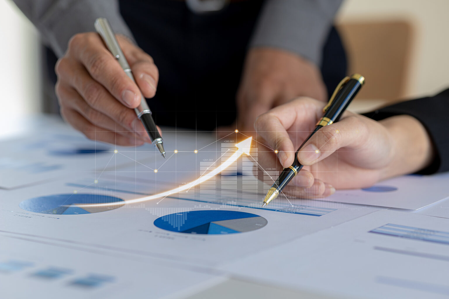 Two businessmen pointing to financial documents to discuss plans and solutions, chart graphics showing financial status and performance