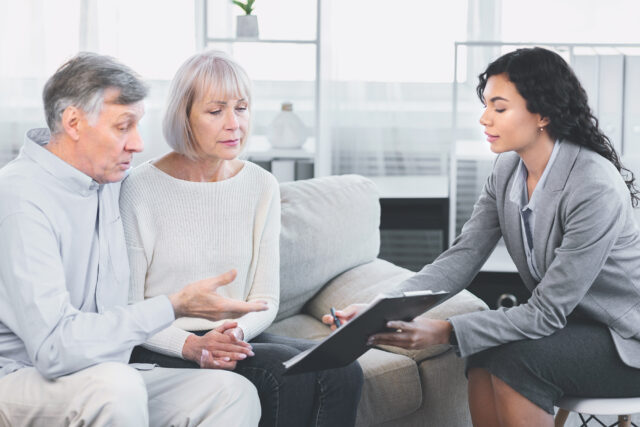 Senior couple talking to their financial advisor looking at a document
