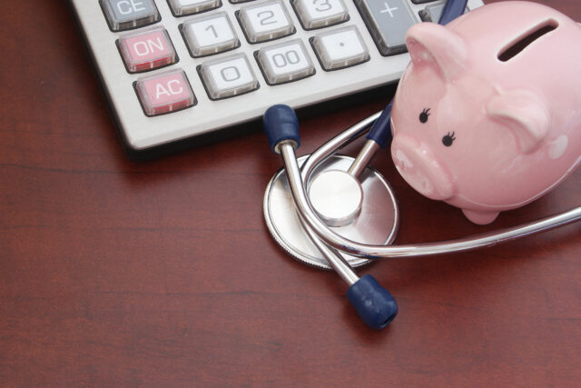 Cost of medical examination concept, piggybank, calculator and s