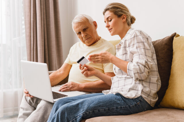 Daughter giving credit card information to her elderly father